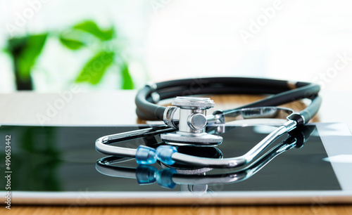 Stethoscope and digital tablet on wooden table