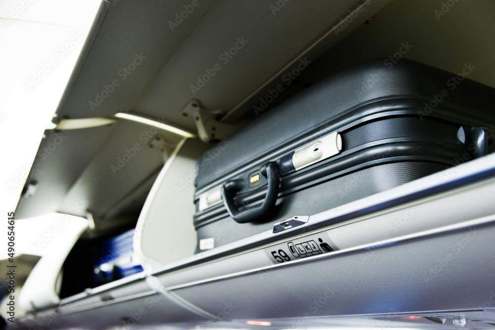 Suitcase on the top shelf of airplane Suitcase on the top shelf of airplane