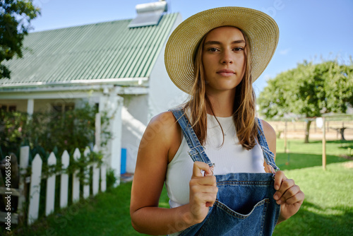 Caucasian female farmer standing out doors with hands on dungarees photo