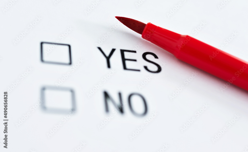 Check boxes YES and NO on paper with pen