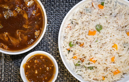 Top view of Vegetable Fried Rice, Hot and Sour soup and Pepper Sauce on a table mat background. 