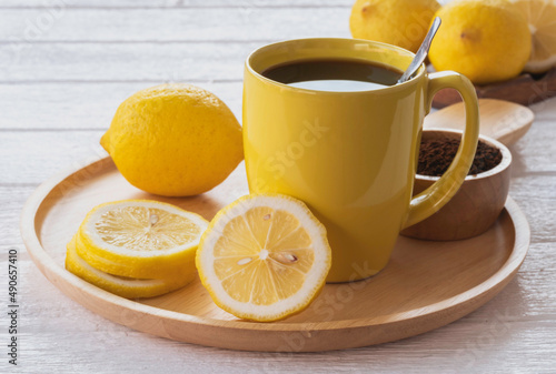 Black coffee lemon in yellow ceramic cup.