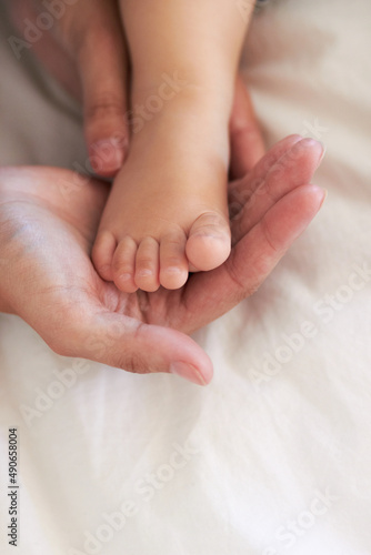 Guiding his footsteps. Cropped image of a mothers hands holding her baby boys foot. © Kusjka D P/peopleimages.com
