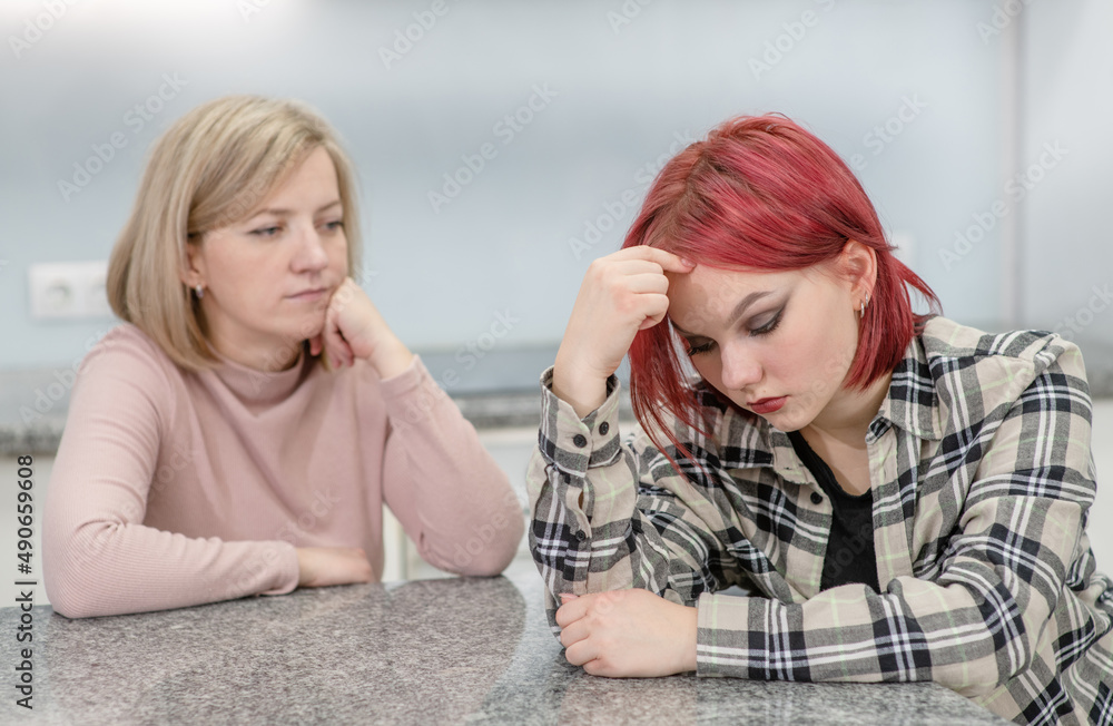 Family conflict. Unhappy mother and guilty daughter are offended at each other Family conflict. Unhappy mother and guilty daughter are offended at each other