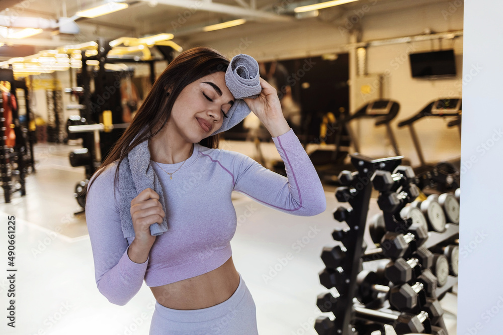Fit young woman with a towel at health club. Female relaxing after ...