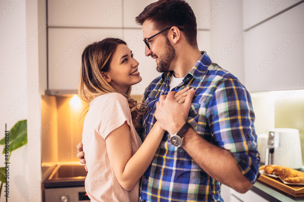Loving couple dancing together in kitchen at home