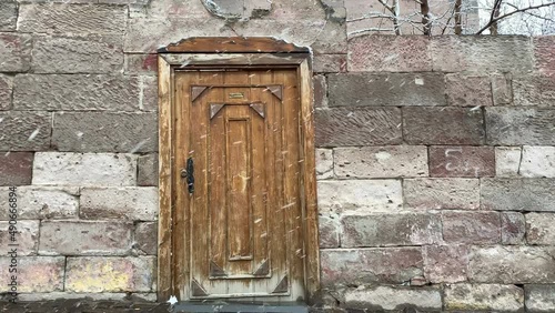Falling snowflakes in front of nostalgic wooden door and stone house