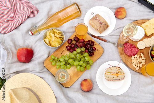 leisure and eating concept - close up of food and drinks on picnic blanket
