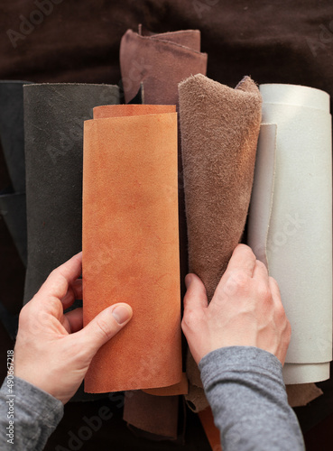 Professional crafter choosing cow leather in roll for making leather items