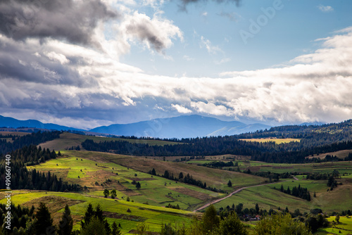 hills with forests in the countryside on a summer cloudy day. mountains landscape background. © robertuzhbt89