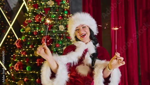 happy woman mrs santa plays with sparklers, sparks delight her.