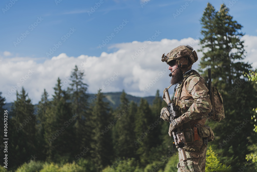 War concept. A bearded soldier in a special forces uniform fighting an enemy in a forest area. Selective focus War concept. A bearded soldier in a special forces uniform fighting an enemy in a forest area. Selective focus