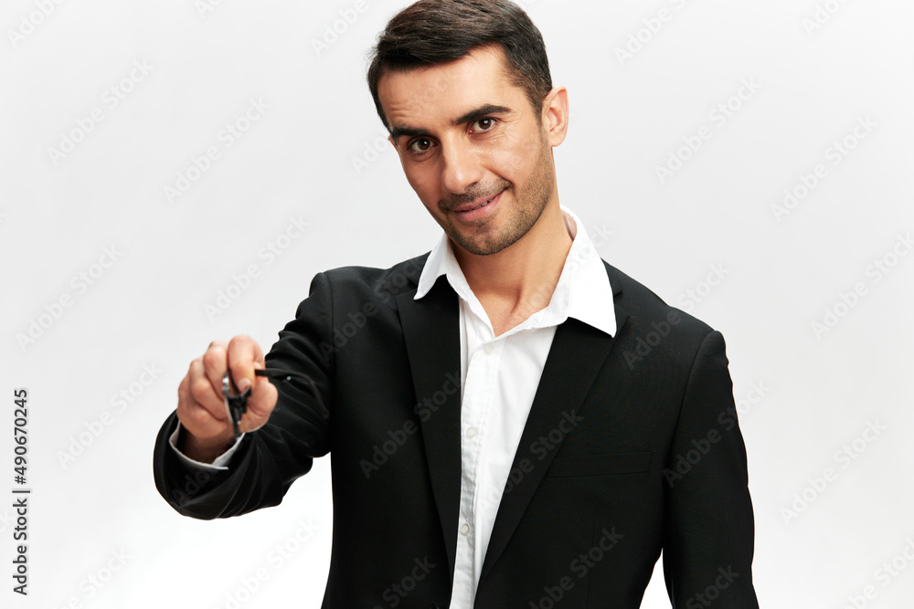 smiling portrait of a white man in a black suit pointing forward with his hand professional work white studio background, copy space smiling portrait of a white man in a black suit pointing forward with his hand professional work white studio background, copy space
