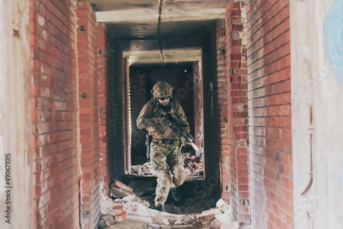 A bearded soldier in uniform of special forces in a dangerous military action in a dangerous enemy area. Selective focus 