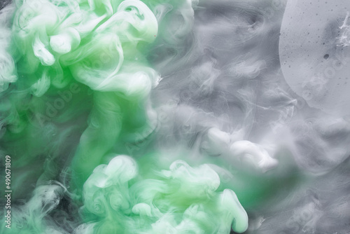 Green smoke on white ink background, colorful fog, abstract swirling emerald ocean sea, acrylic paint pigment underwater