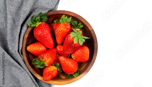 Fresh organic red strawberry in wooden bowl with grey apron on white background.