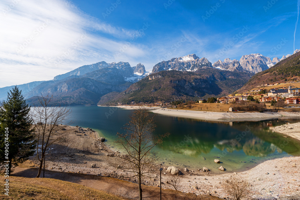 Molveno village, tourist resort on the coast of the lake Molveno with the mountain range of Brenta Dolomites in winter. National Park of Adamello Brenta. Trentino Alto Adige, Trento, Italy, Europe.