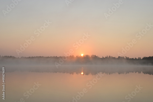 Sunrise on the lake. Forest lake in the early morning in summer. Foggy spring landscape © maxa0109