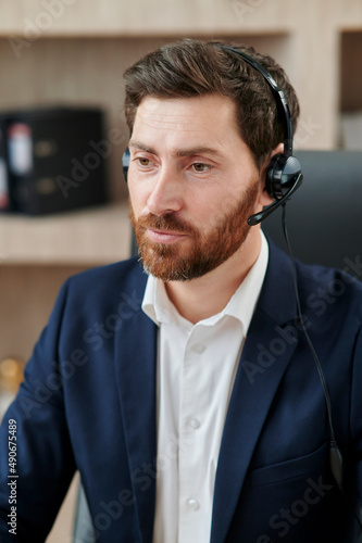 Fotografie Representive practitioner leads online training wearing a suit and headset, with
