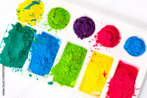 Photography Multicolored holi paints in a palette on a white background from above close-up