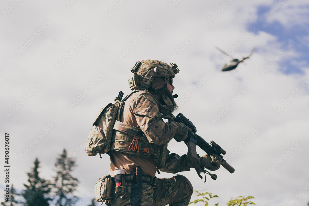 War concept. A bearded soldier in a special forces uniform fighting an enemy in a forest area. Selective focus War concept. A bearded soldier in a special forces uniform fighting an enemy in a forest area. Selective focus