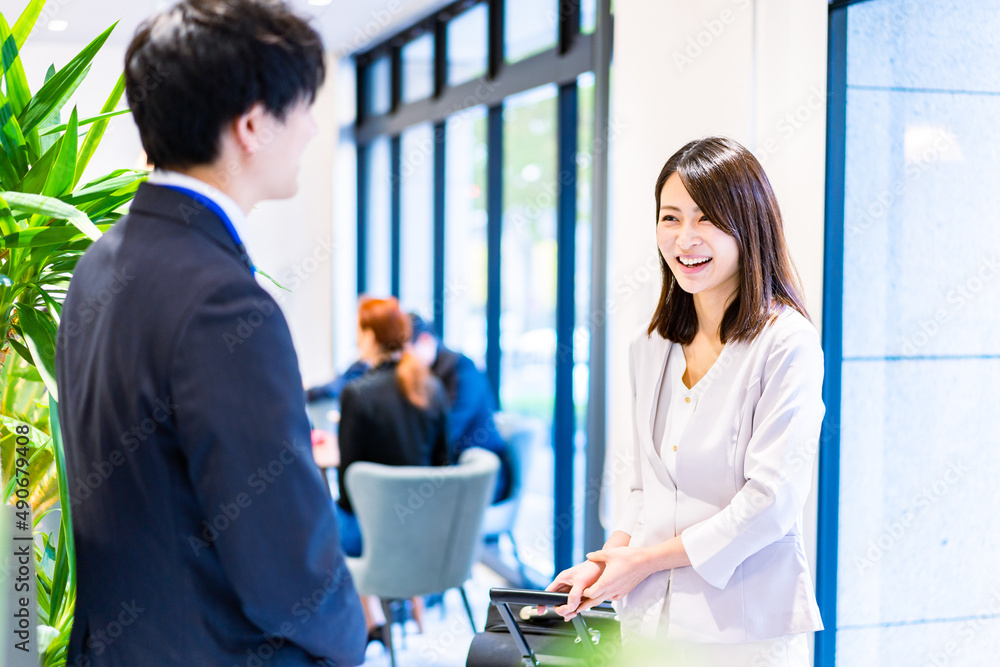Fototapeta premium フロントでホテルのチェックインをする若いビジネスウーマン