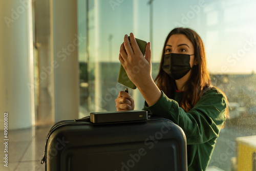 Obraz na płótnie Young girl at the airport charging her smartphone w salonie