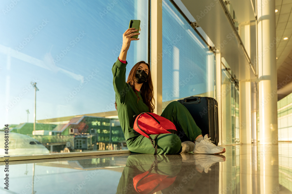 Woman on video call sitting on airport floor
