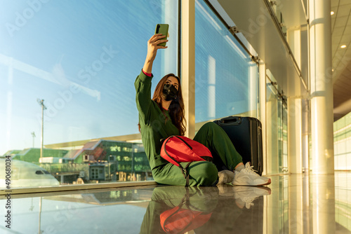 Woman on video call sitting on airport floor