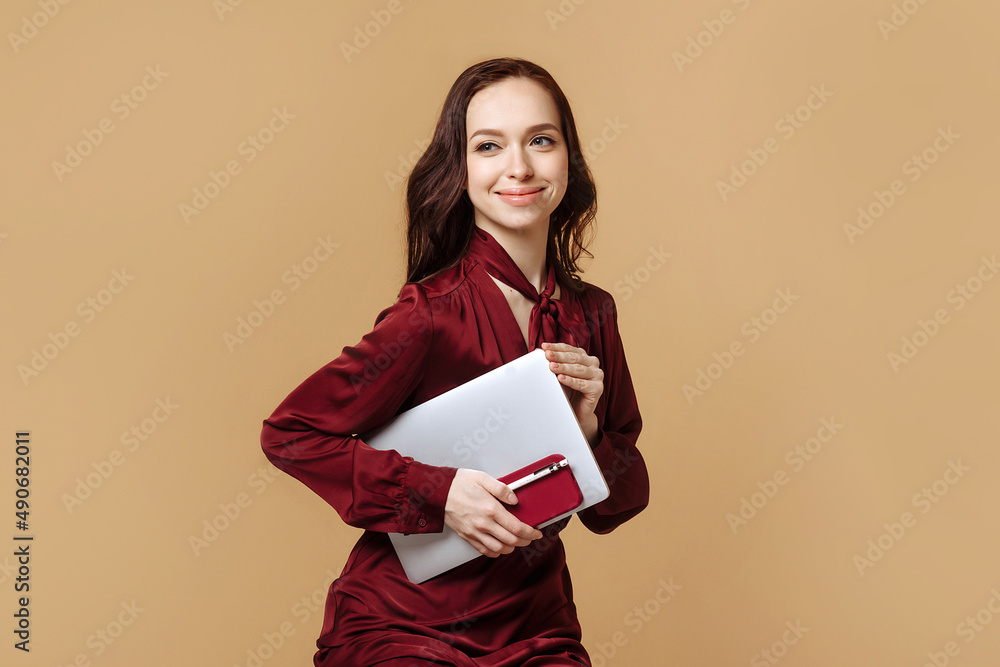 A woman holds a laptop and a phone in her hand A woman holds a laptop and a phone in her hand