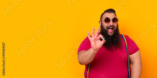Big happy bearded man wearing sunglasses and doing a perfect hand sign