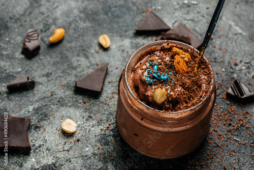 chocolate ice cream drizzled with chocolate in a glass jar on dark background, banner, menu, recipe place for text, top view photo