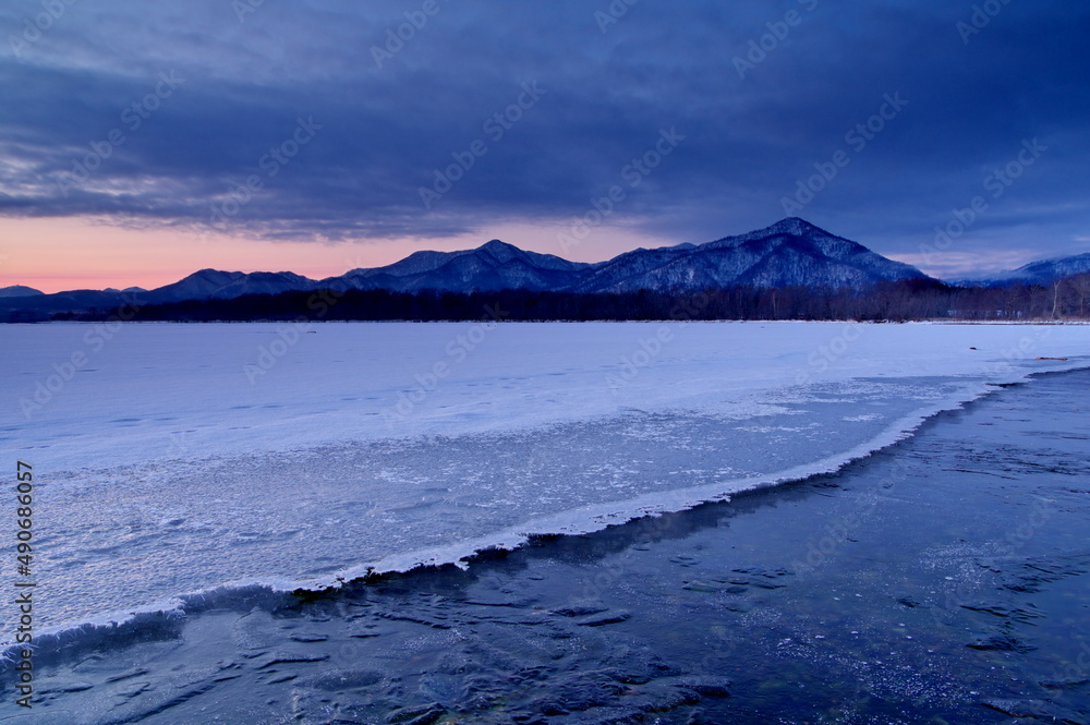 氷の覆われた湖の夜明け。日本の北海道の屈斜路湖の冬。