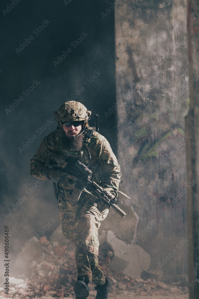A bearded soldier in uniform of special forces in a dangerous military action in a dangerous enemy area. Selective focus 