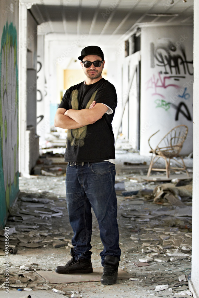 Graffiti is our art. A graffiti artist standing in front of a graffiti wall. Graffiti is our art. A graffiti artist standing in front of a graffiti wall.