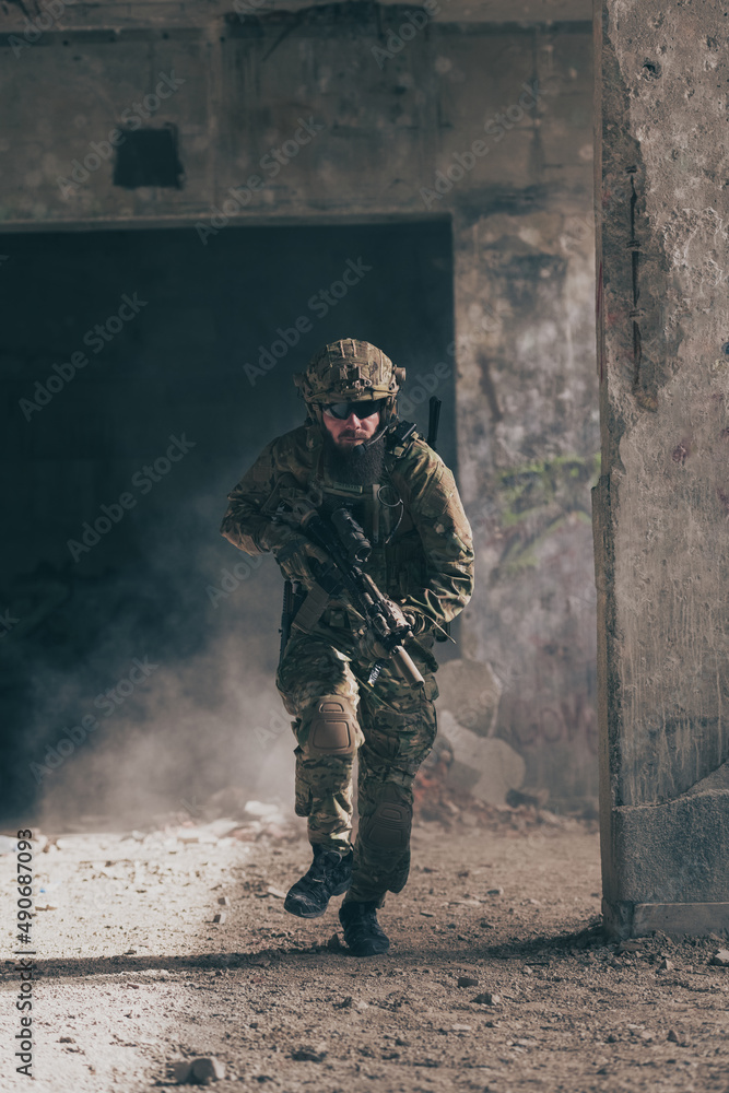 A bearded soldier in uniform of special forces in a dangerous military action in a dangerous enemy area. Selective focus A bearded soldier in uniform of special forces in a dangerous military action in a dangerous enemy area. Selective focus