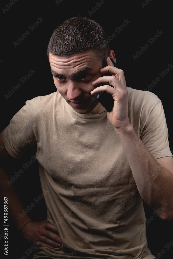 Studio portrait of a man with a smartphone on a black background. Studio portrait of a man with a smartphone on a black background.