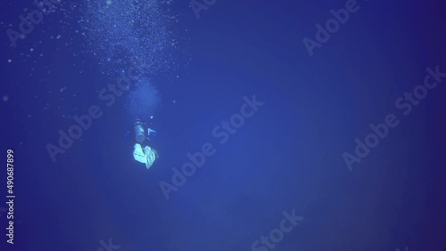 man swim with aqualung underwater. Maldives