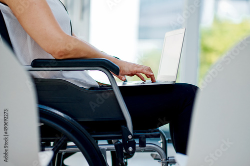 I have a disability but that wont stop me. Cropped shot of an unrecognizable businesswoman using her laptop in the office.
