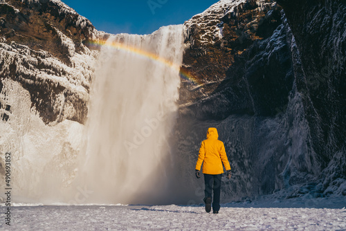 Obraz na płótnie Spanish woman with yellow coat at skogafoss waterfall w salonie