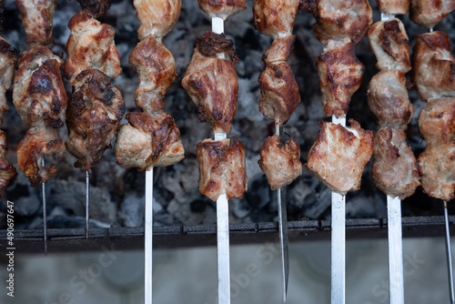 Georgian national dish meat on a spit, grilled on a large metal grill with hot charcoal, the meat is golden brown.