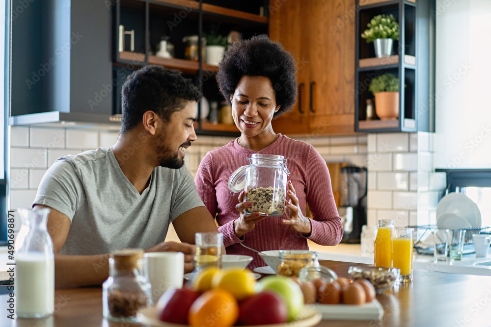Happy african american couple having breakfast together in the kitchen