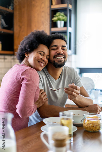 Happy african american couple having breakfast together in the kitchen