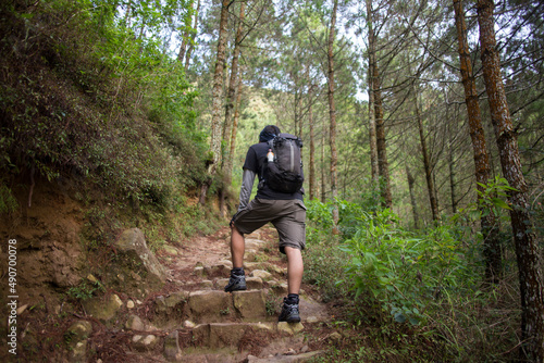 One backpacker man travel alone, with backpack in the mountains
