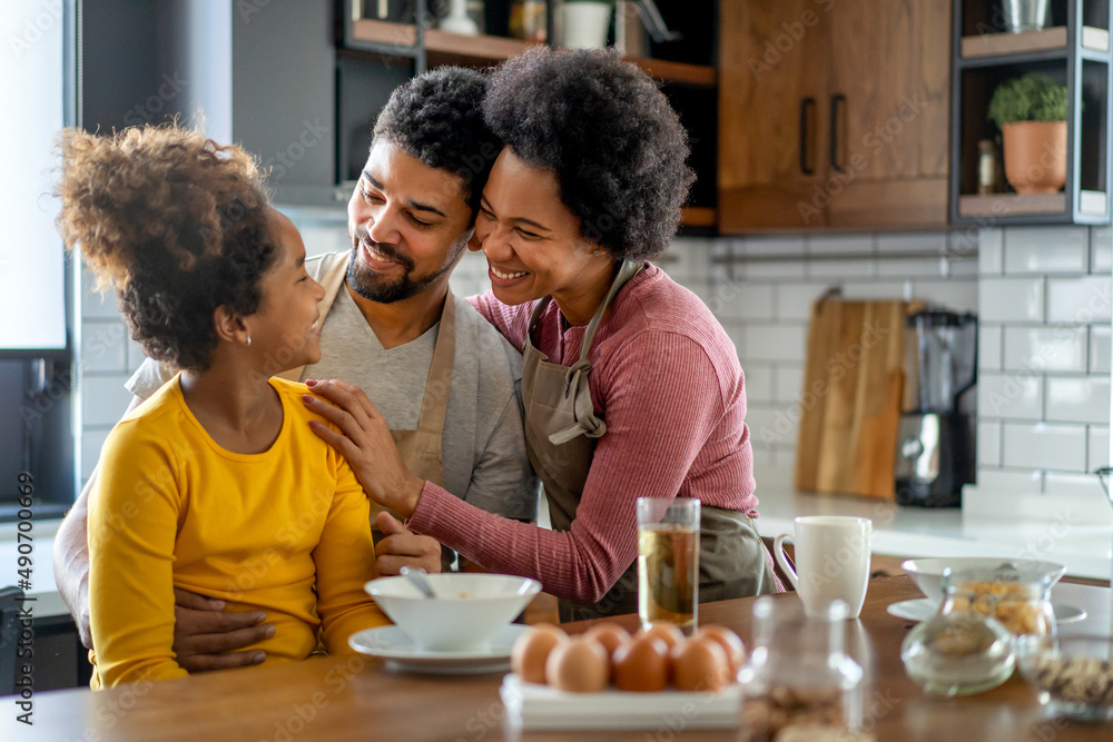 Happy african american family preparing healthy food together in kitchen Happy african american family preparing healthy food together in kitchen