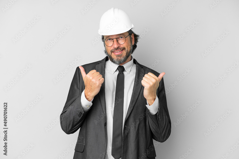 Young architect man with helmet over isolated background with thumbs up gesture and smiling Young architect man with helmet over isolated background with thumbs up gesture and smiling