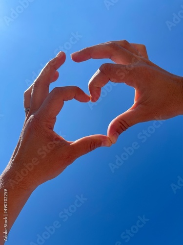 Two blurred beautiful LGBT girls, lesbian couple of women are showing sign in shape of heart with fingers, hands. Homosexual love, relationships.