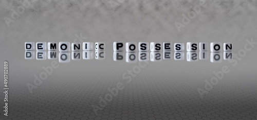 demonic possession word or concept represented by black and white letter cubes on a grey horizon background stretching to infinity