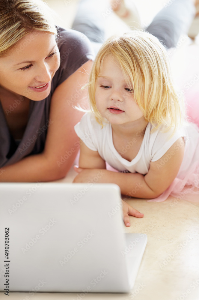 Watching cartoons on the laptop. A little girl and her mother using a laptop. Watching cartoons on the laptop. A little girl and her mother using a laptop.