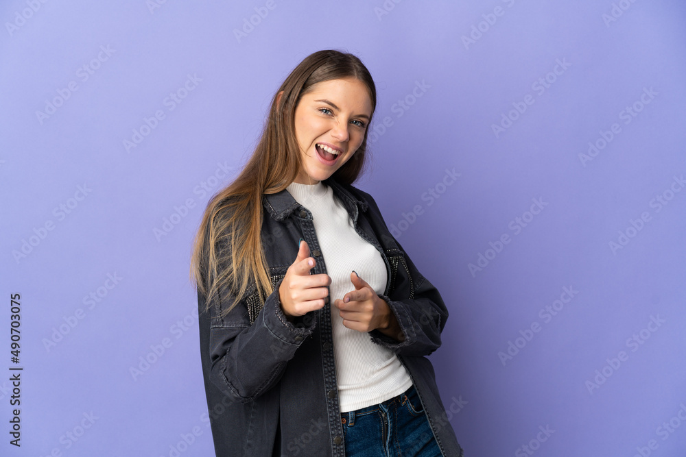 Young Lithuanian woman isolated on purple background pointing to the front and smiling Young Lithuanian woman isolated on purple background pointing to the front and smiling